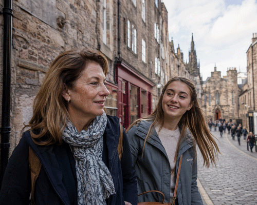 Mother and daughter walking side-by-side through a stone‑built Edinburgh street, natural candid moment on a tailor-made Girls' Trip with High Point Holidays.