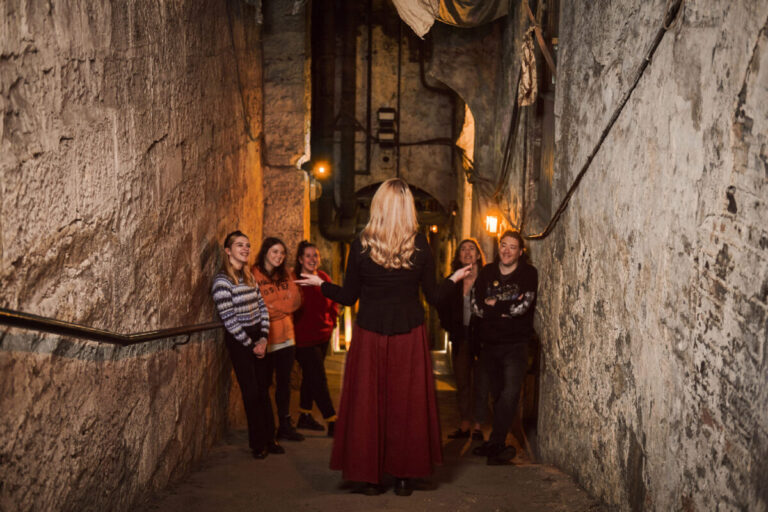Guide leading visitors through the Real Mary King’s Close underground streets while explaining history — a private Girls' Trip / Mother & Daughter experience with High Point Holidays.