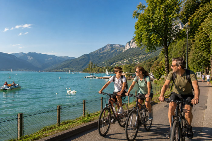 Family cycling along Lake Annecy during a tailor-made family holiday in France.