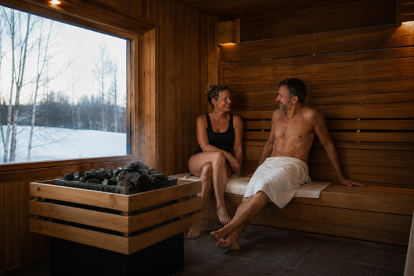 Couple relaxing in a traditional Finnish sauna during a winter journey through Finland