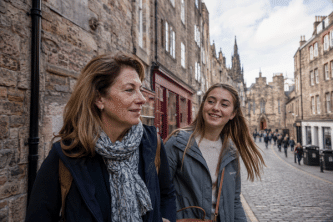 Mother and daughter walking side-by-side through a stone‑built Edinburgh street, natural candid moment on a tailor-made Girls' Trip with High Point Holidays.